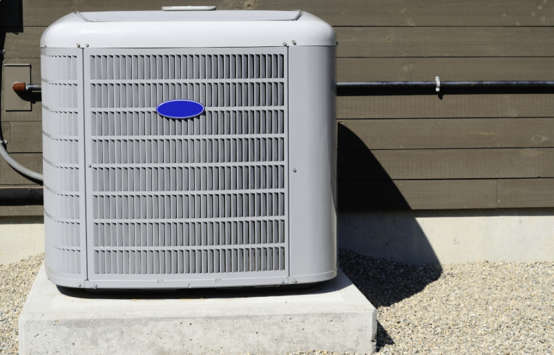 Residential central A/C condenser unit installed on a concrete pad